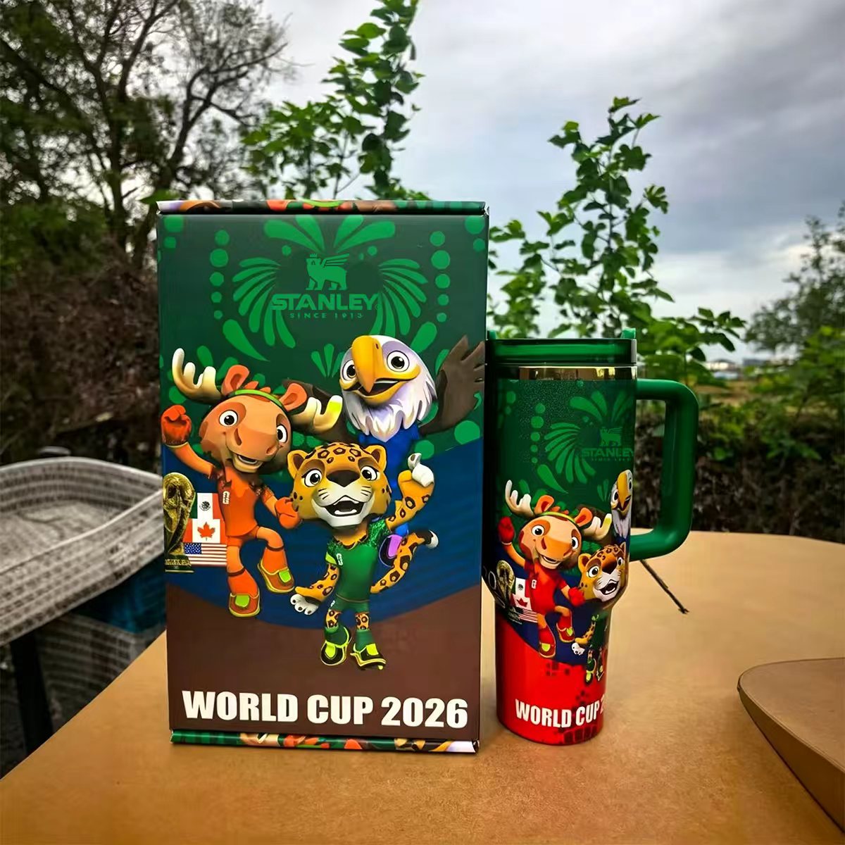 Stanley 40oz insulated tumbler featuring 2026 World Cup mascots, vibrant green and red design, includes matching World Cup-themed gift box