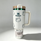 Stanley 40oz insulated tumbler with Hello Kitty full-face pattern on pink background, light pink handle