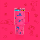 Stanley 40oz insulated tumbler featuring Snoopy illustrations, blue paw prints and bone icons, white body with white ergonomic handle
